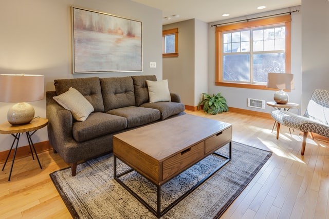 a%20beige%20living%20room%20with%20light%20wood%20flooring%20and%20a%20small%20couch a%20beige%20living%20room%20with%20light%20wood%20flooring%20and%20a%20small%20couch